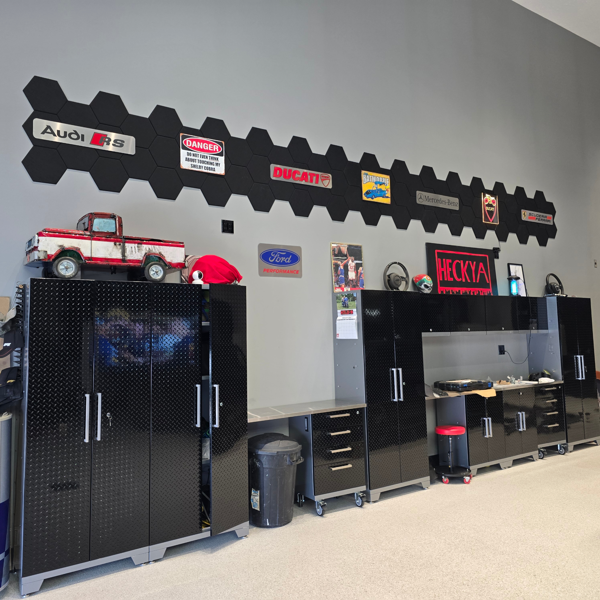 Hex panel wall with Audi RS, Ducati, Ferrari, Mercedes, Ford Performance, and HECKYA neon