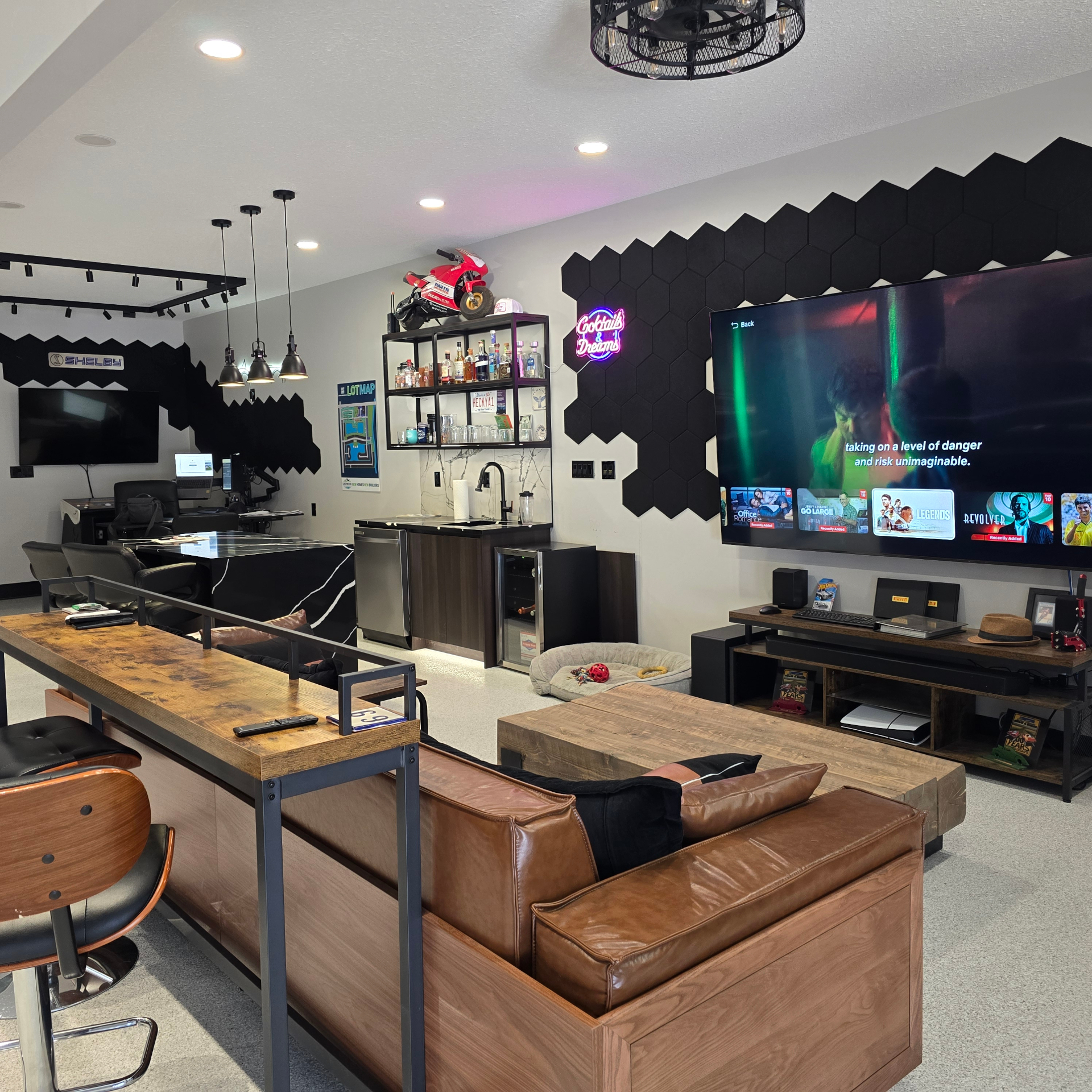 Studio lounge with Shelby wall, bar, neon, and big-screen viewing area